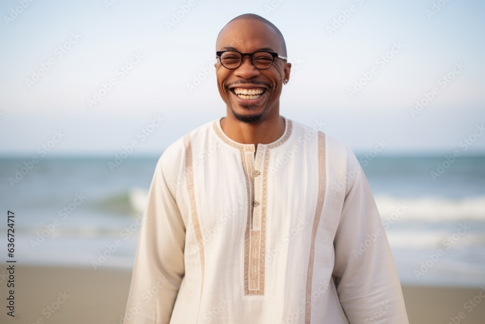 Lifestyle portrait of a Nigerian man in his 40s in a beach background wearing a simple tunic Lifestyle portrait of a Nigerian man in his 40s in a beach background wearing a simple tunic