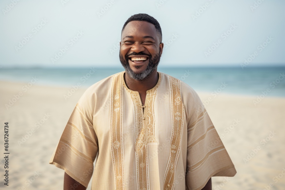 Lifestyle portrait of a Nigerian man in his 40s in a beach background wearing a simple tunic