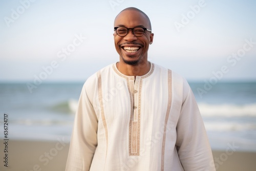 Lifestyle portrait of a Nigerian man in his 40s in a beach background wearing a simple tunic © Leon Waltz