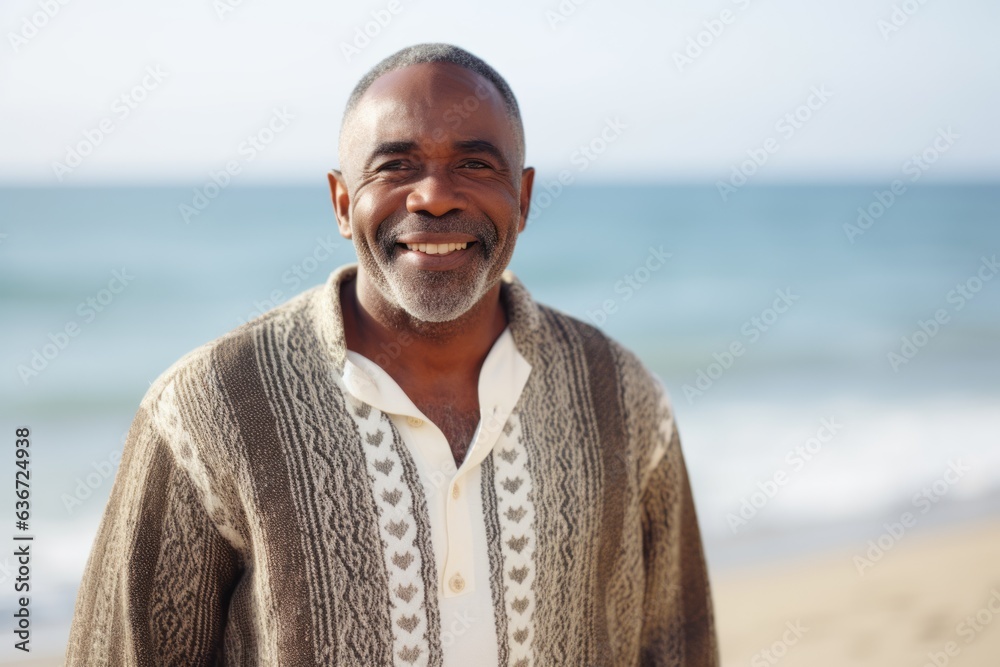 Lifestyle portrait of a Nigerian man in his 50s in a beach background wearing a chic cardigan Lifestyle portrait of a Nigerian man in his 50s in a beach background wearing a chic cardigan