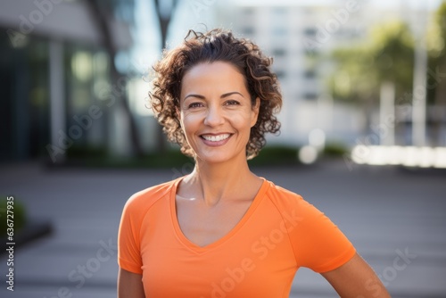 Portrait of smiling sportswoman standing outside on a sunny day