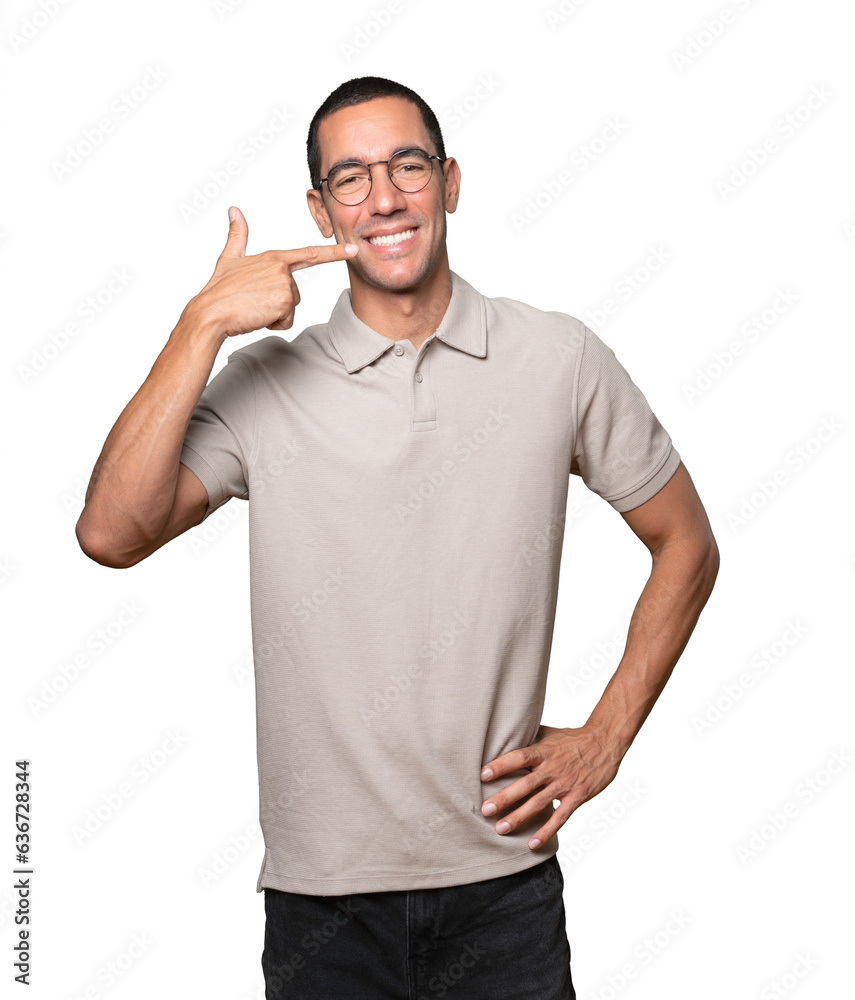 Young man pointing to his teeth Young man pointing to his teeth