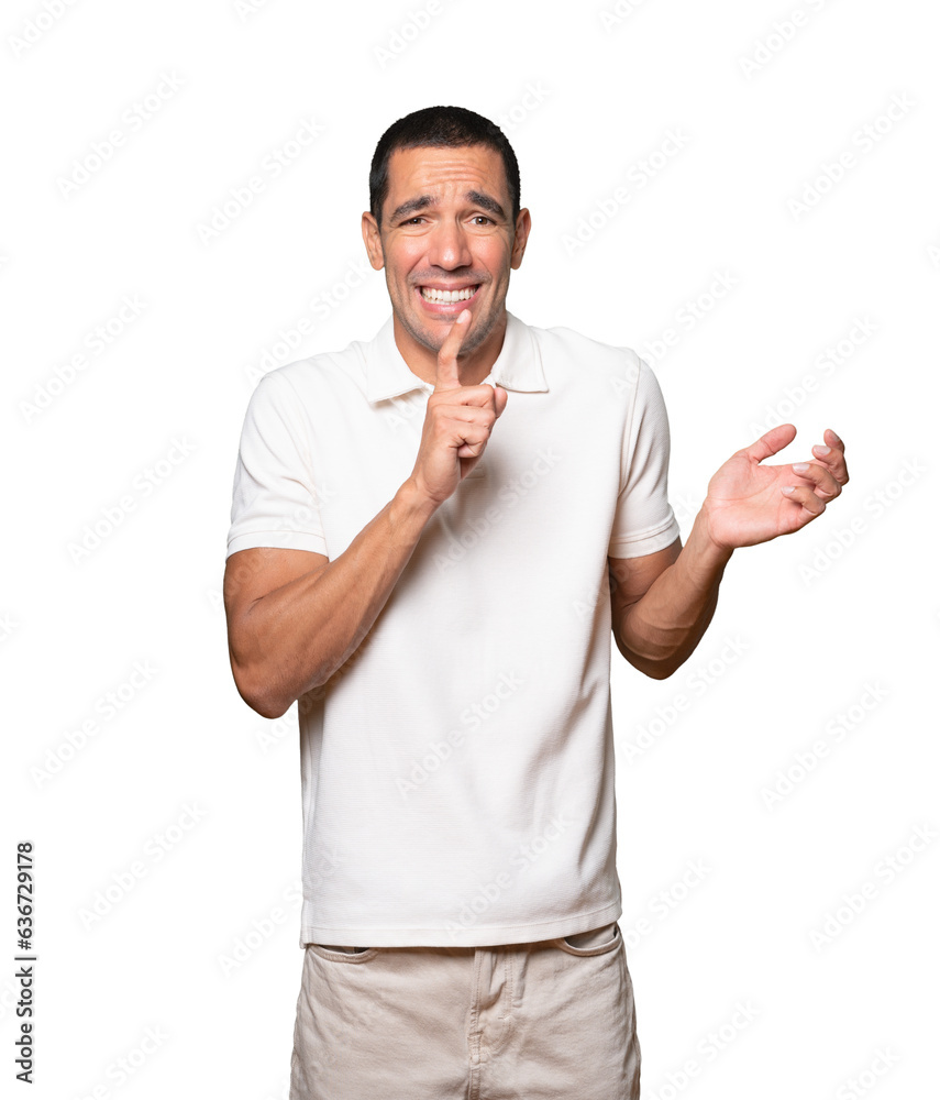 Amazed young man asking for silence gesturing with his finger Amazed young man asking for silence gesturing with his finger