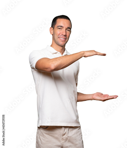 Confident young man doing a gesture of holding something with his hands