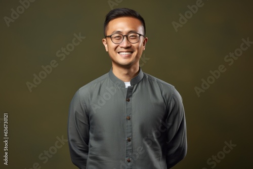 smiling asian man in eyeglasses and shirt on green background