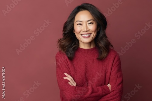 Portrait of a beautiful asian woman in red sweater smiling at the camera © Leon Waltz