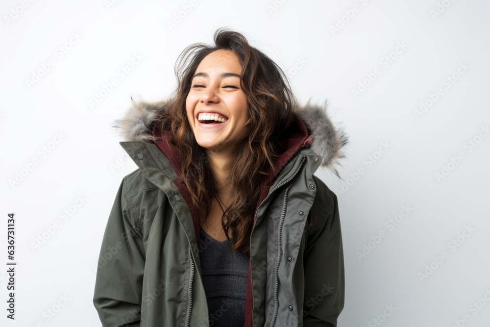 Portrait of a Chinese woman in her 30s in a white background wearing a warm parka