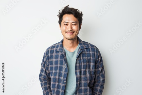 Portrait of a Chinese man in his 30s in a white background wearing a snuggly pajama set