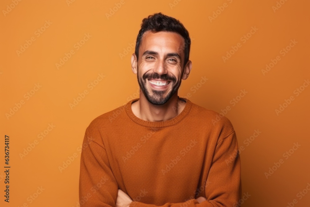 Obraz premium Portrait of a happy young man standing with arms crossed over yellow background