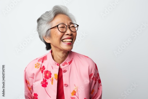 Obraz na płótnie Asian senior woman wearing eyeglasses standing against white background and laughing w salonie