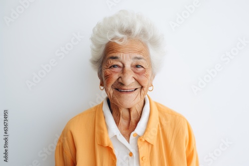 Portrait of a happy senior woman smiling at camera while standing against white background