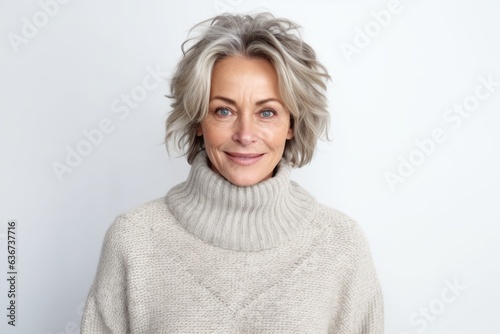 Portrait of mature woman with grey hair in sweater on white background
