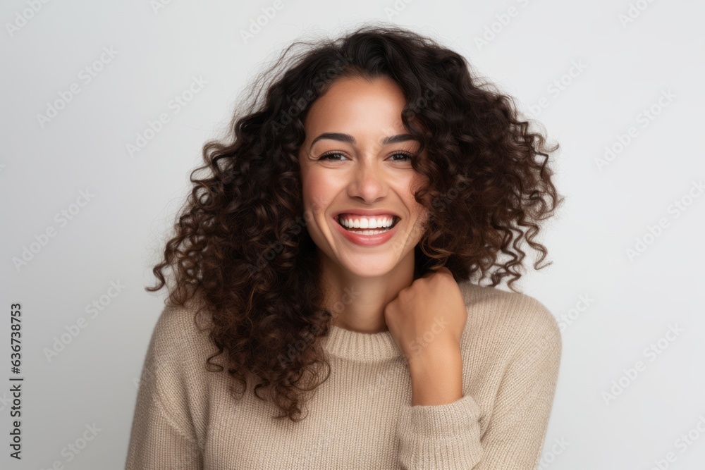 Portrait of a beautiful young woman with curly hair smiling and looking at camera isolated on a white background
