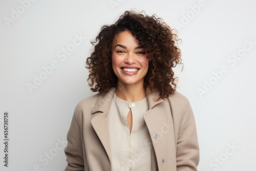 Portrait of a smiling young businesswoman standing against a white background