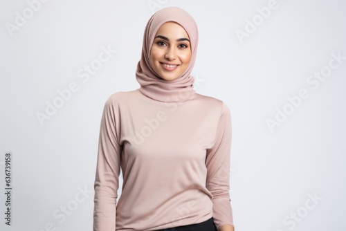 Portrait of a Saudi Arabian woman in her 30s in a white background wearing a cozy sweater