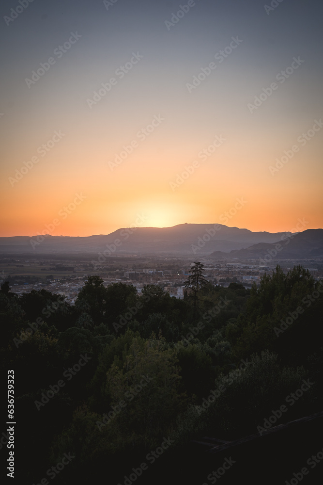 view of the city of granada during sunset with the mountain view of the city of granada during sunset with the mountain
