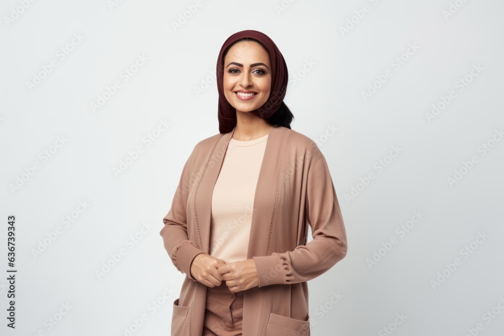 Portrait of a Saudi Arabian woman in her 30s in a white background wearing a chic cardigan Portrait of a Saudi Arabian woman in her 30s in a white background wearing a chic cardigan