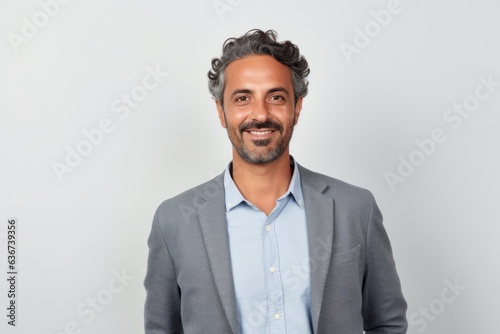 Portrait of a Saudi Arabian man in his 40s in a white background wearing a chic cardigan