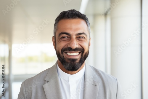 Portrait of smiling businessman looking at camera in corridor of office building