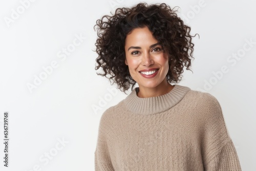 Portrait of a Saudi Arabian woman in her 40s in a white background wearing a cozy sweater