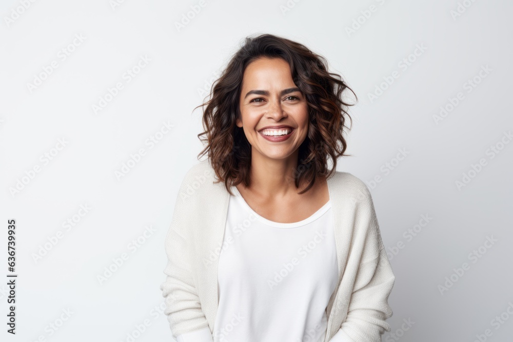 Portrait of a Saudi Arabian woman in her 40s in a white background wearing a chic cardigan Portrait of a Saudi Arabian woman in her 40s in a white background wearing a chic cardigan