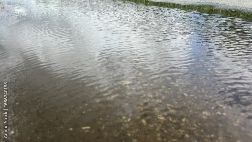 wind waving water puddle reflecting cloudy sky wind waving water puddle reflecting cloudy sky