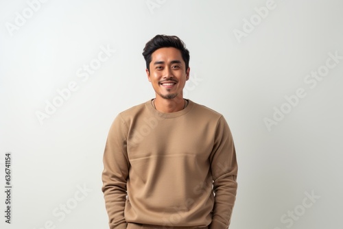Portrait of a happy young asian man smiling against white background © Eber Braun
