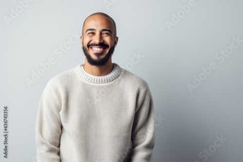 Portrait of a handsome young african american man smiling at the camera while standing against grey background