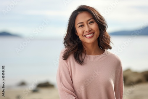Portrait of a beautiful young asian woman smiling on the beach © Eber Braun