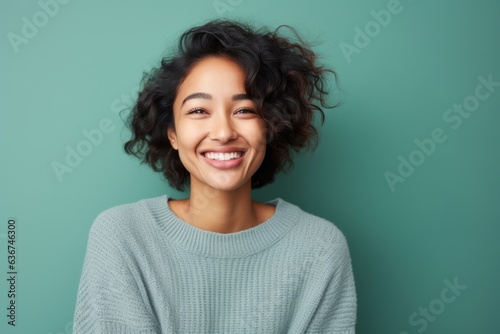 Portrait of a Indonesian woman in her 20s in an abstract background wearing a cozy sweater