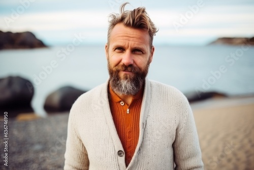 Portrait of a bearded man in a sweater on the beach.