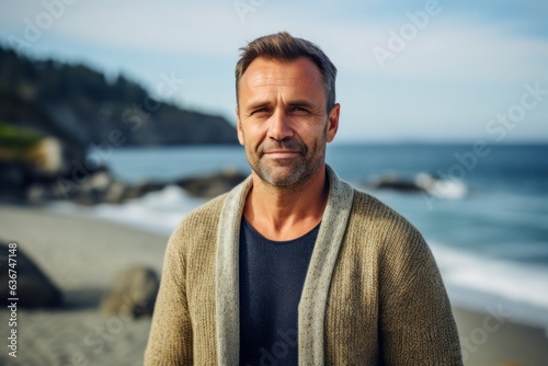 Portrait of handsome mature man on the beach in autumn season.