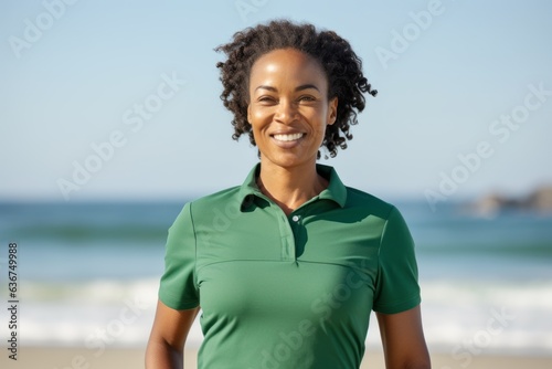 Portrait of a smiling young woman standing with arms akimbo on the beach