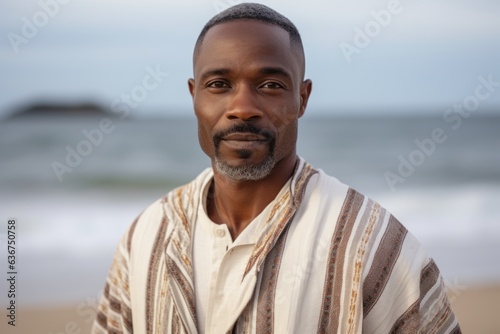 Portrait of confident mature man standing on beach at the day time