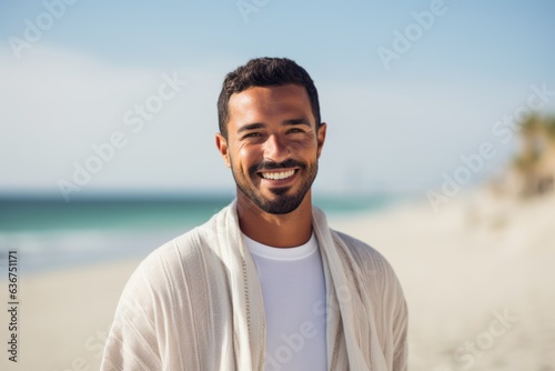 Portrait of smiling young man standing on beach at the day time