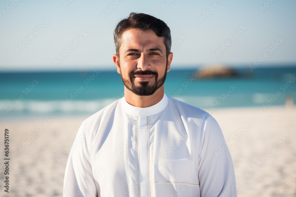 Portrait of smiling muslim man standing on the beach at sunny day Portrait of smiling muslim man standing on the beach at sunny day