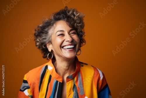 Portrait of a Brazilian woman in her 50s in an abstract background wearing a chic cardigan