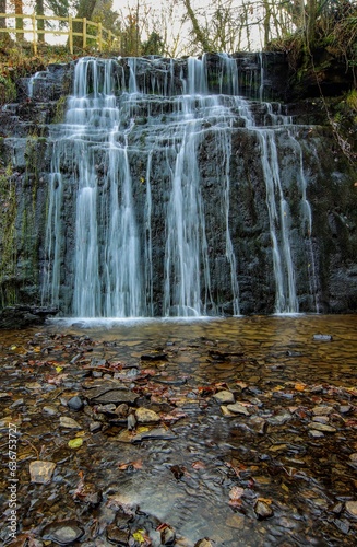 Fototapeta Naklejka Na Ścianę i Meble -  Vertical shot of the Waterfall in Saint Llanwanno forest, South Wales