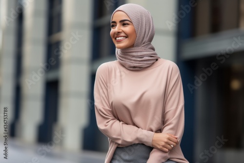 Portrait of a Saudi Arabian woman in her 30s in an abstract background wearing a cozy sweater