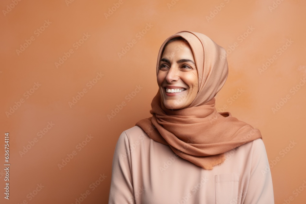 Portrait of a Saudi Arabian woman in her 50s in an abstract background wearing a cozy sweater