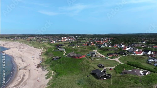 Aerial Shot Of Houses In Village On Green Landscape By Islands, Denmark, view of luxury houses is located near the sea, and the road, Traditional Scandinavian village with colorful houses by the sea photo