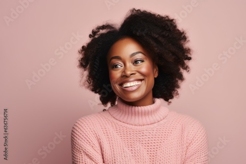 Portrait of a Nigerian woman in her 30s in a pastel or soft colors background wearing a cozy sweater © Hanne Bauer