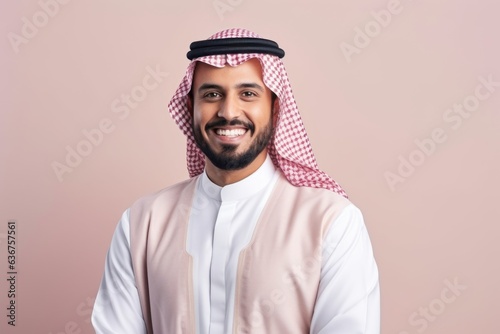 Medium shot portrait of a Saudi Arabian man in his 30s in a pastel or soft colors background wearing a chic cardigan