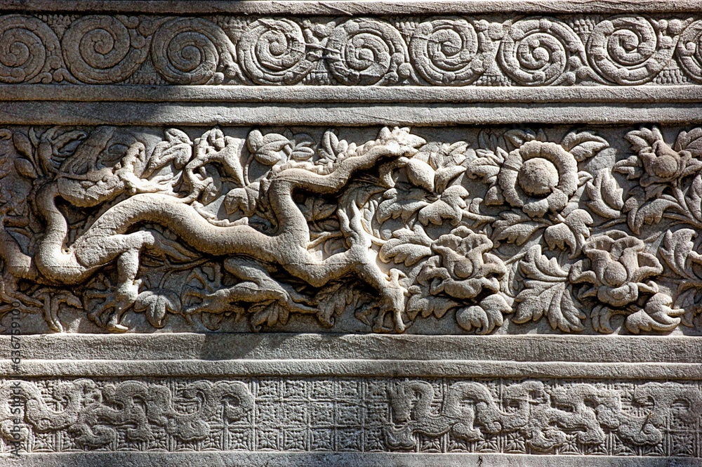Mystical and majestic dragon depicted on a stone wall backdrop, with vibrant floral design