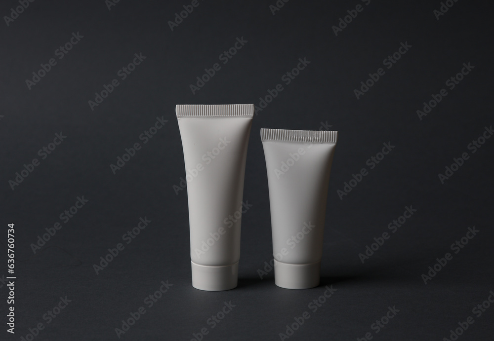White blank cream tubes on dark background. Template for design, mockup. Beauty concept White blank cream tubes on dark background. Template for design, mockup. Beauty concept