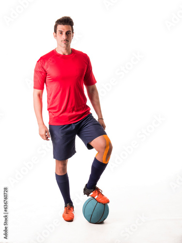 Photo of a man in a red shirt standing next to a blue ball in an isolated studio setting © theartofphoto