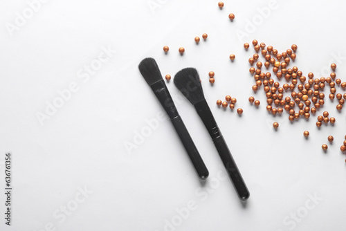 Black make-up brushes with powder ball on white background. Flat lay, beauty concept