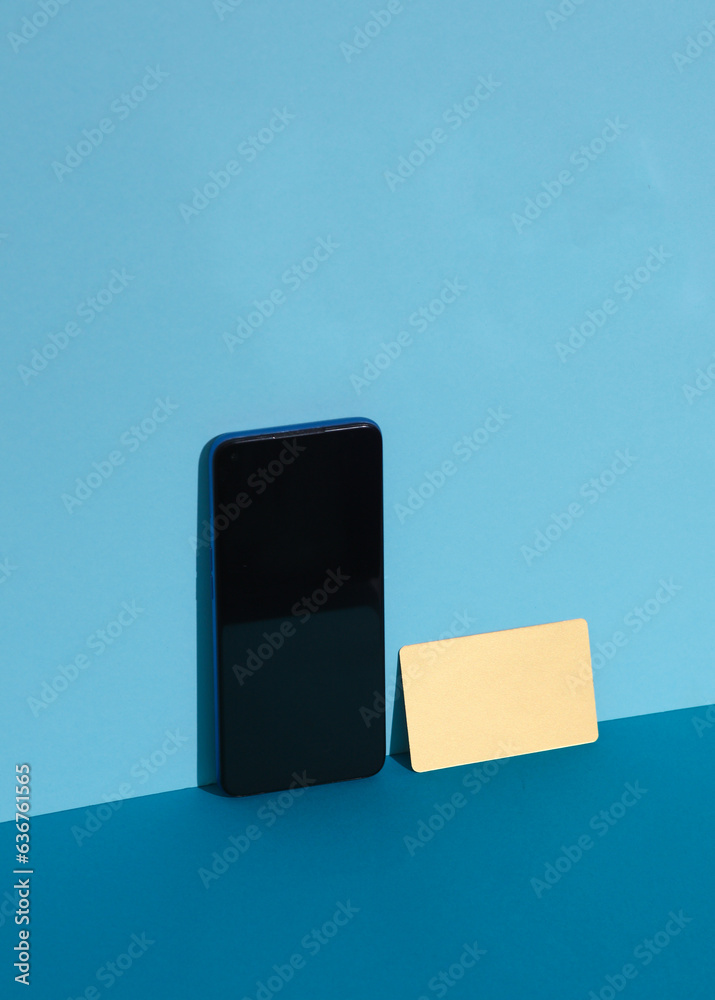 Golden business card with smartphone on blue background. Creative business layout