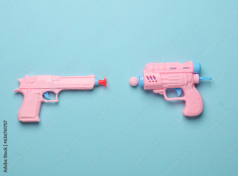 Two Plastic guns on blue background. Minimalism Two Plastic guns on blue background. Minimalism