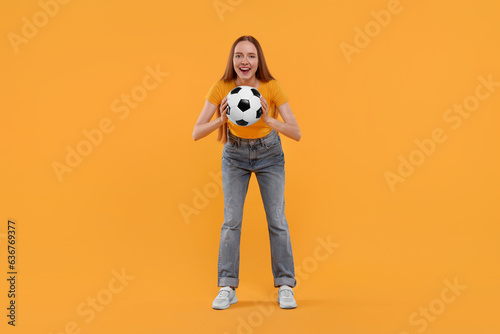 Emotional sports fan with ball on yellow background